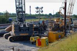 Liebherr HS 855 und daneben (rechts) die Verrohrungsmaschine
