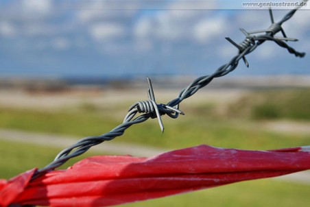 Impression von Stacheldraht und Absperrband am Bauzaun Jade-Weser-Port