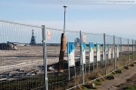 Vor dem Bauzaun der JadeWeserPort-Baustelle in Wilhelmshaven