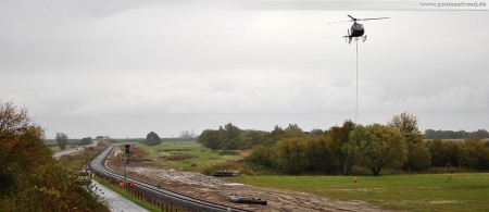 Voslapper Groden Süd - Höhe Deichschäferei: Montage der Eisenbahnsignale per Hubschrauber